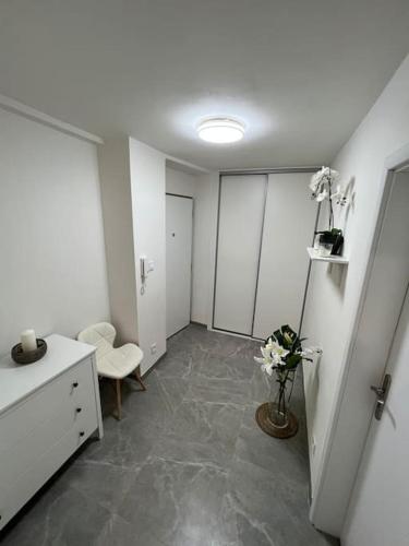 een kamer met een witte kamer met een kamer met een tafel en bloemen bij Romantický úkryt s krbem v centru Prahy in Praag
