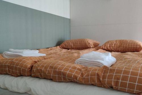 a bed with two pillows and towels on it at Kodikas juuri remontoitu yksiö keskustassa in Hämeenlinna