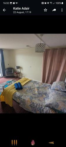 a bedroom with a bed with a yellow and blue blanket at peaceful one bedroom apartment in Antrim
