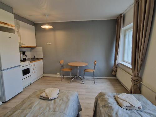 una cocina con 2 camas y una mesa. en Humppilantie en Jokioinen