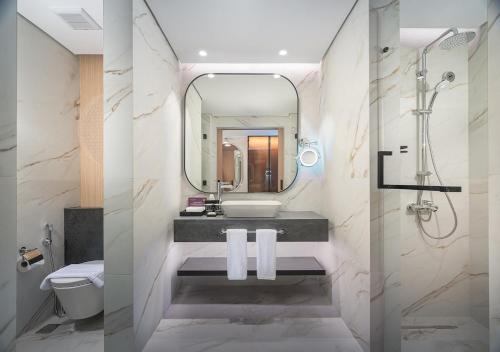 a bathroom with a sink and a mirror at JOUDYAN Red Sea Mall Jeddah By ELAF in Jeddah
