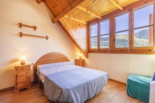 1 dormitorio con 1 cama en una habitación con ventanas en La Cabanyeta de la Vall de Boí, en Pla de l'Ermita
