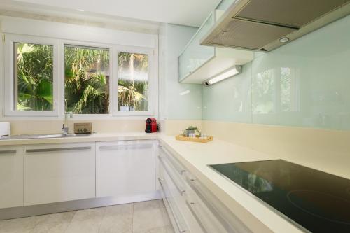 une cuisine avec des placards blancs et une fenêtre dans l'établissement Penthouse with sea views in Nueva Andalucia, à Marbella