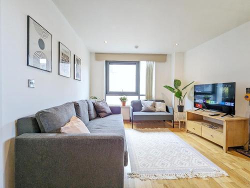 a living room with a couch and a flat screen tv at Guest Rooms In City Centre Near Key Attractions in Liverpool