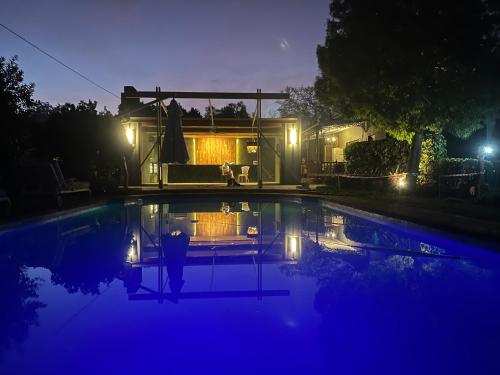 a house with a swimming pool at night at La Pension Guest House in Oudtshoorn