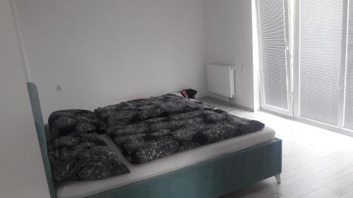 a bed with a black comforter in a room at House Juraj Čarný Zalužice 
