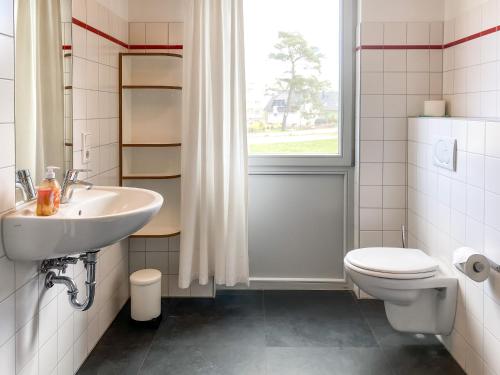 La salle de bains est pourvue d'un lavabo, de toilettes et d'une fenêtre. dans l'établissement Familienunterkunft Wiesengeflüster S3 - kinderfreundlich, nur 3 Minuten zum Strand, à Röbel