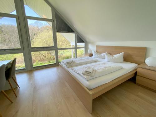 una camera con un grande letto e una grande finestra di Familienhaus Wiesengeflüster W11 - kinderfreundlich und nur 300 m zum Strand a Röbel