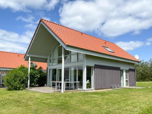 a building with an orange roof with a picnic table at Wiesengeflüster S5 Gruppenhaus haustierfrei mit Aussicht, Wiese und Müritznähe in Röbel