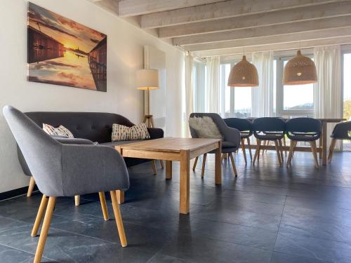 a living room with a couch and a table and chairs at Gruppenunterkunft Wiesengeflüster S2 mit Wiesenblick, Sauna und Kamin in Röbel