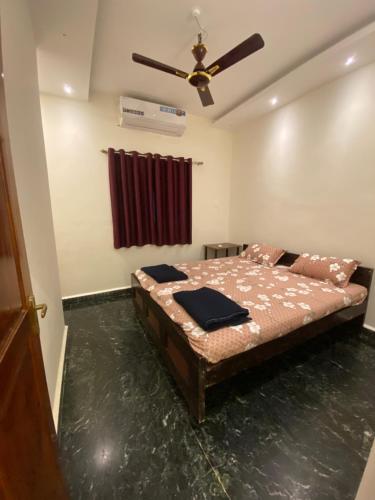 a bedroom with a bed and a ceiling fan at Palolem Apartments in Palolem