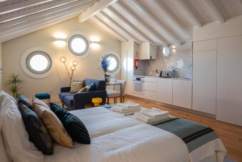 a bedroom with a large bed and a kitchen at Nautical Luxury Loft in Porto
