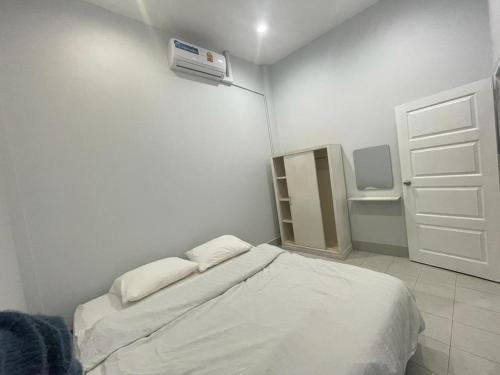 a white room with a bed and a fan at VS appartment in Vientiane