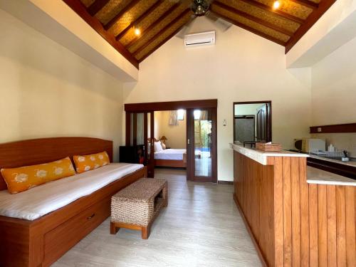 a living room with a bed and a kitchen at 1 BR Balinese Villa In The Heart of Sanur in Sanur