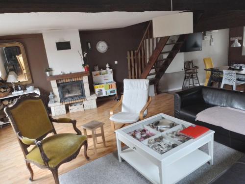 uma sala de estar com um sofá e uma mesa em MAISON DU CLOCHER em Le Planquay