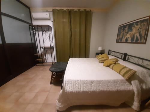 a bedroom with a large bed with yellow pillows at San Nicolò House in Aci Catena