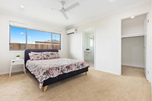 a bedroom with a bed and a window at 'The Pool House' Spacious Family Stay at Hervey Bay in Hervey Bay