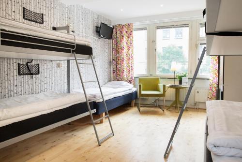 a bedroom with two bunk beds and a desk at Slottsskogens Hostel in Gothenburg