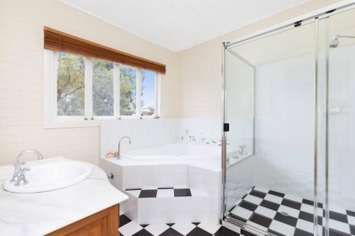een badkamer met een bad, een wastafel en een douche bij Coastal Queenslander with Fraser Island Views in Boonooroo