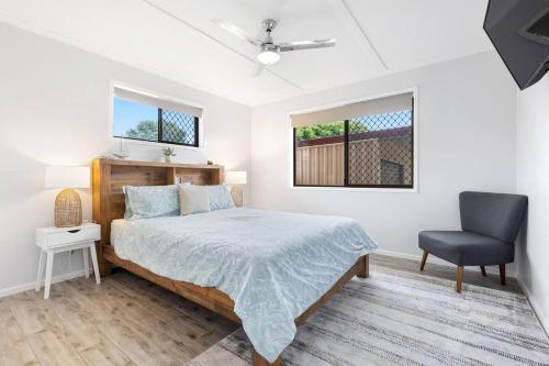 um quarto com uma cama e uma cadeira em 'The Aussie Classic' Poolside Living by the Marina em Urangan