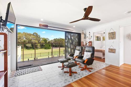 a living room with a large sliding glass door with a balcony at Discover Coastal Living Perfection at Point Vernon in Hervey Bay
