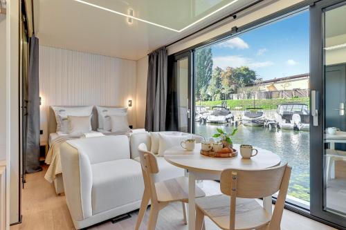 ein Hotelzimmer mit einem Bett, einem Tisch und einem Fenster in der Unterkunft Domy Na Wodzie - La Mare Motlava Houseboats with Sauna by Downtown Apartments in Danzig