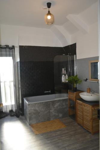 a bathroom with a bath tub and a sink at Gîte LORLAVIE in Arudy