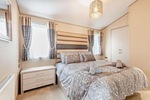 a bedroom with a bed and a window at Artisan Lodge Shorefield Country Park Downton Lymington in Lymington