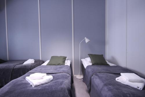 a room with three beds with towels on them at Forenom Hostel Espoo Kilo in Espoo
