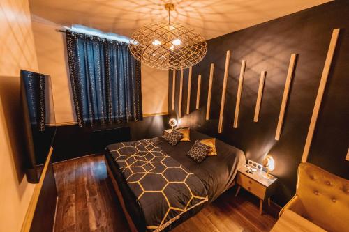 瓦朗西納的住宿－L'eSPAce détente，一间卧室配有一张床和一个吊灯