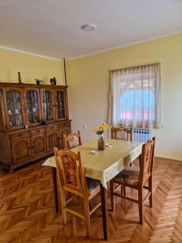 una sala da pranzo con tavolo e sedie in legno di Prenoćište Mali Raj a Valjevo