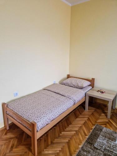 a small bedroom with a bed and a table at Prenoćište Mali Raj in Valjevo