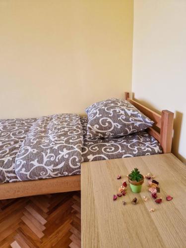 a bedroom with a bed and a table with a plant on it at Prenoćište Mali Raj in Valjevo