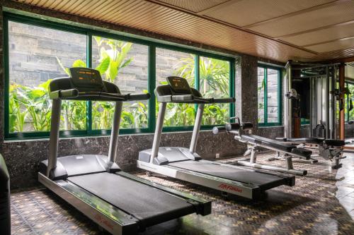a row of treadmills in a gym with windows at La Siesta Hoi An Resort & Spa in Hoi An