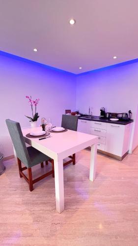 mesa blanca con 2 sillas y cocina en CUORE OPENSPACE, en Morcote