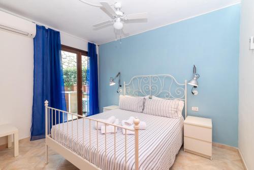 een slaapkamer met een bed met een blauwe muur bij A 101 Puntavilla Mare in La Maddalena