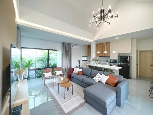 a living room with a blue couch and a kitchen at Harmonic HuaHin Pool Villa-3BR, 3 Bath, 2 Kitchen in Hua Hin