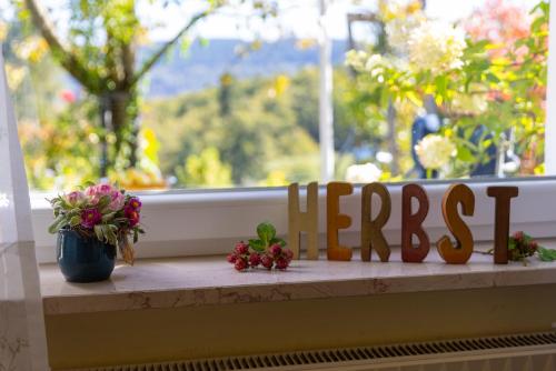 a wooden sign sitting on a window sill with flowers at Ferienwohnung Trapp in Winterberg
