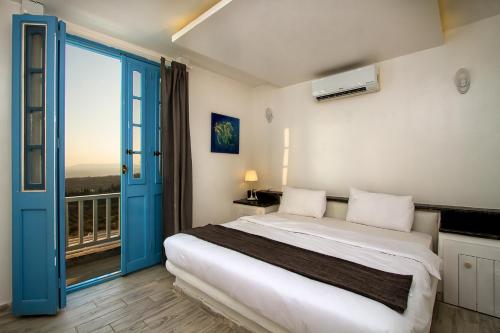 a bedroom with a bed and a balcony at VILLA NAYA Branch 3 - SANTORINI, Jerash in Rujm al Miḑmār