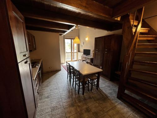 a kitchen with a table and a kitchen with a staircase at Chalet Edelweiss - Estella Hotel Collection in Sestriere
