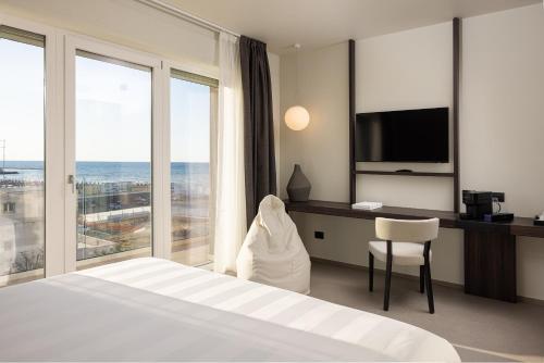 a hotel room with a bed and a desk with a television at B21 Lifestyle Hotel in Bari