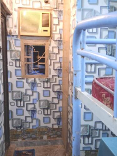 een kamer met een muur met een raam en een gebouw bij Venus Homestay in Calcutta