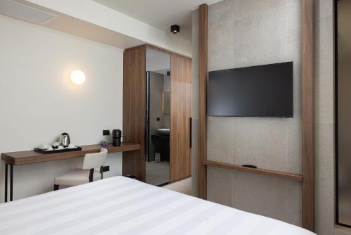 a hotel room with a bed and a television on a wall at B21 Lifestyle Hotel in Bari