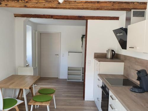 eine Küche mit einem Holztisch und grünen Stühlen in der Unterkunft Landgasthof Lamm Ferienwohnungen in Burladingen