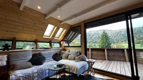 een woonkamer met een bank en een groot raam bij Chalet Le 36 Le Mont Dore 6pers in Le Mont-Dore