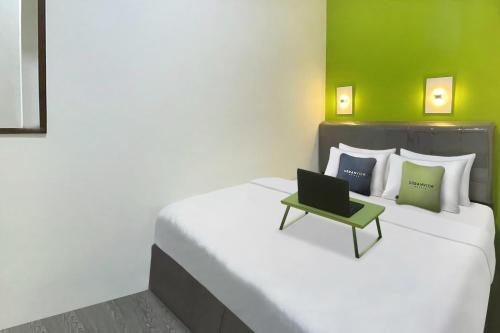 a bedroom with a bed with a laptop on it at Urbanview Syariah Don Juan Pondok Gede in Warungsergon