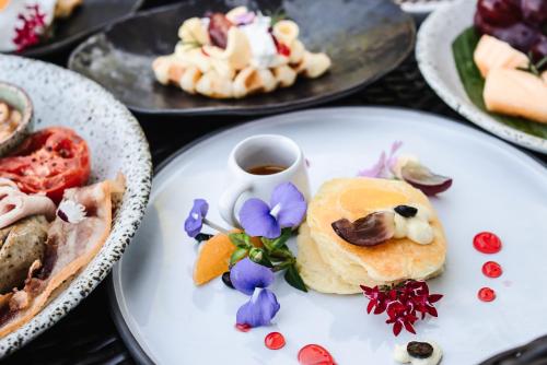 a plate of food with purple flowers on it at Thantara Resort Chiang Mai in Chiang Mai