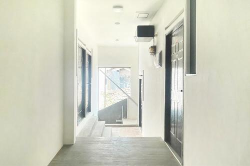 a hallway of a house with white walls and a door at Urbanview Don Juan Pondok Gede by RedDoorz in Warungsergon