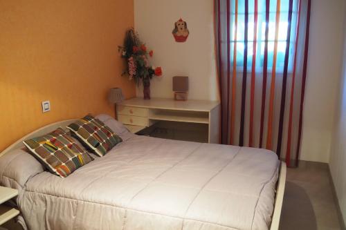 niewielka sypialnia z łóżkiem i biurkiem w obiekcie gure xokoa w mieście Urrugne