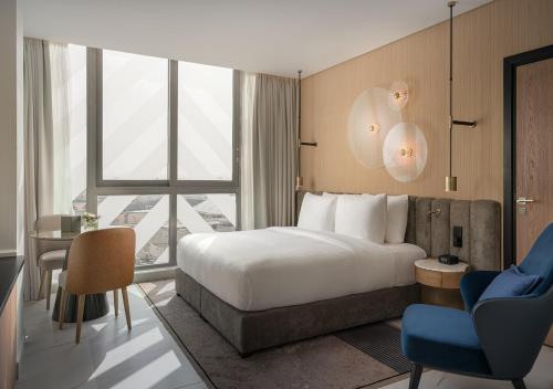 a hotel room with a bed and a desk and a window at JOUDYAN Red Sea Mall Jeddah By ELAF in Jeddah